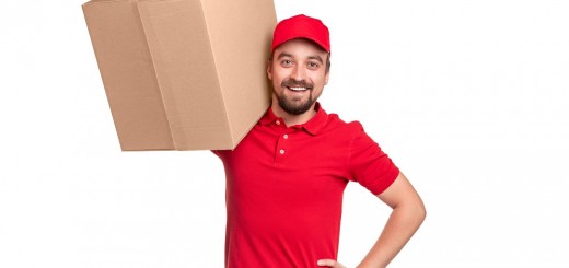 Cheerful delivery man carrying box