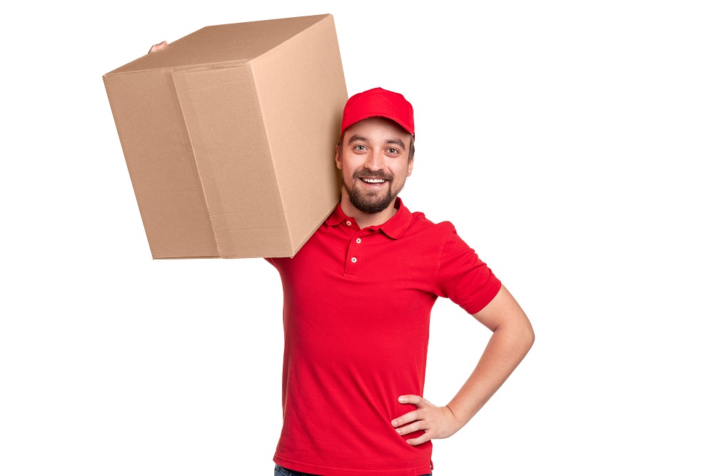 Cheerful delivery man carrying box